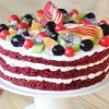 Red Velvet Cake with Fresh Fruit - Moist red velvet cake with creamy frosting, topped with a colorful medley of seasonal fruits, perfect for any celebration