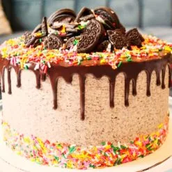 Oreo Chocolate Confetti Cake - Moist chocolate sponge with Oreo cream, adorned with confetti, Oreo cookie crumbs, and whole cookies, perfect for celebrations